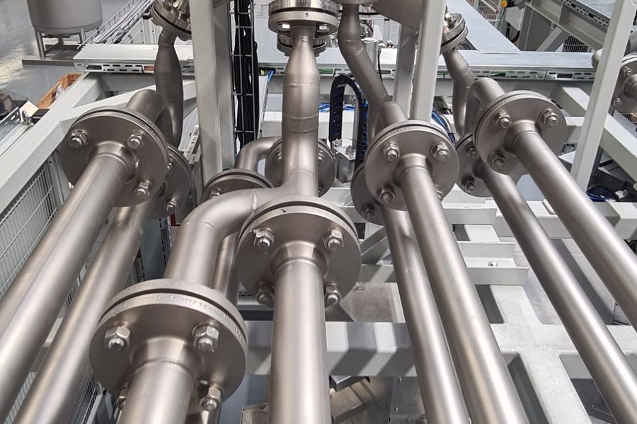 Verbundene Edelstahlrohre mit Flanschen in einer industriellen Umgebung.